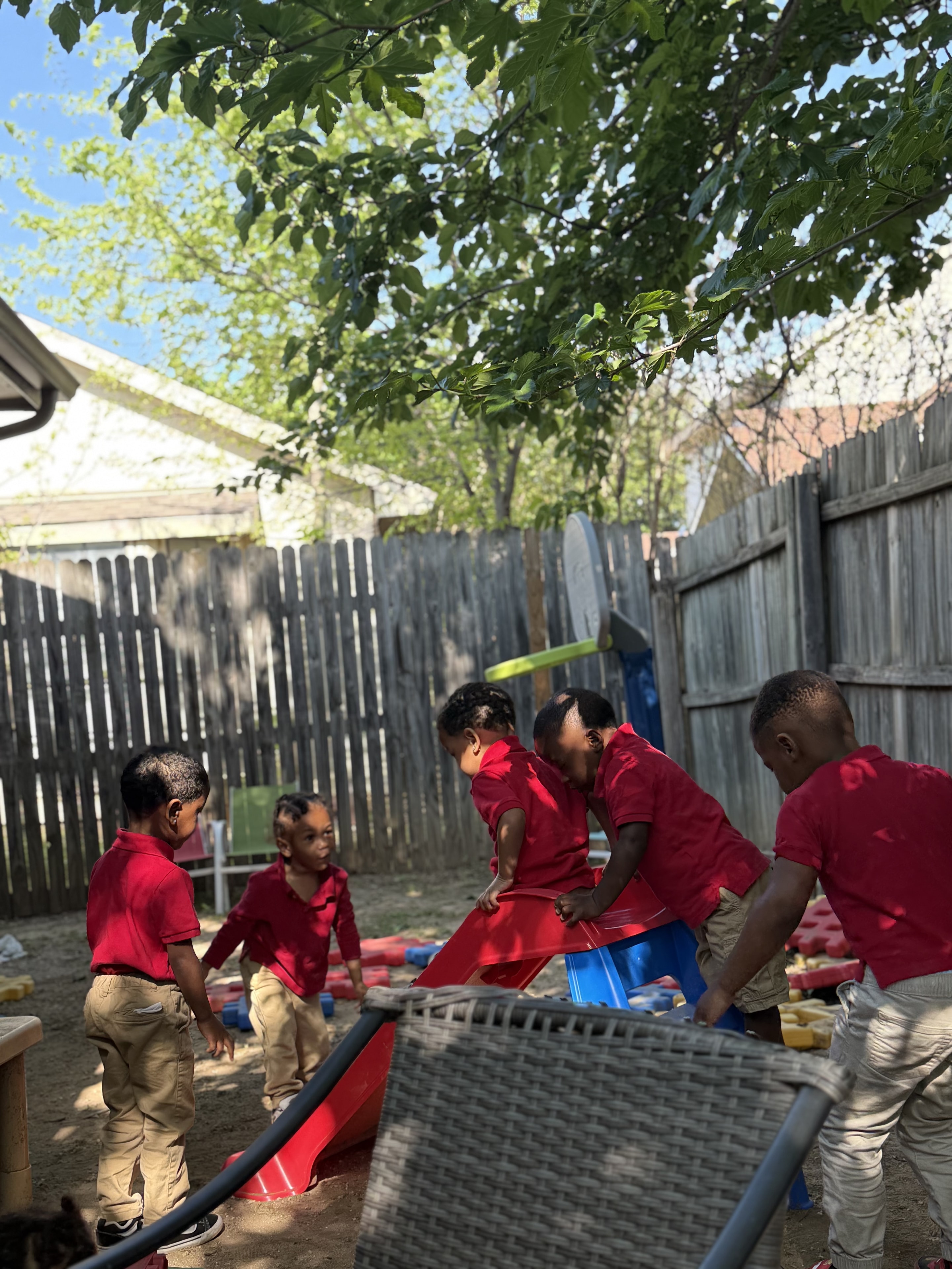 Children in red uniforms playing in the backyard